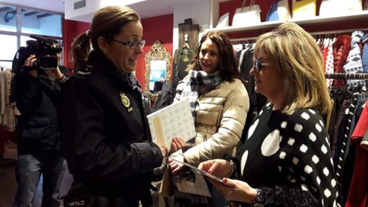 Un agente de la Policía Nacional informa a los dueños de una tienda