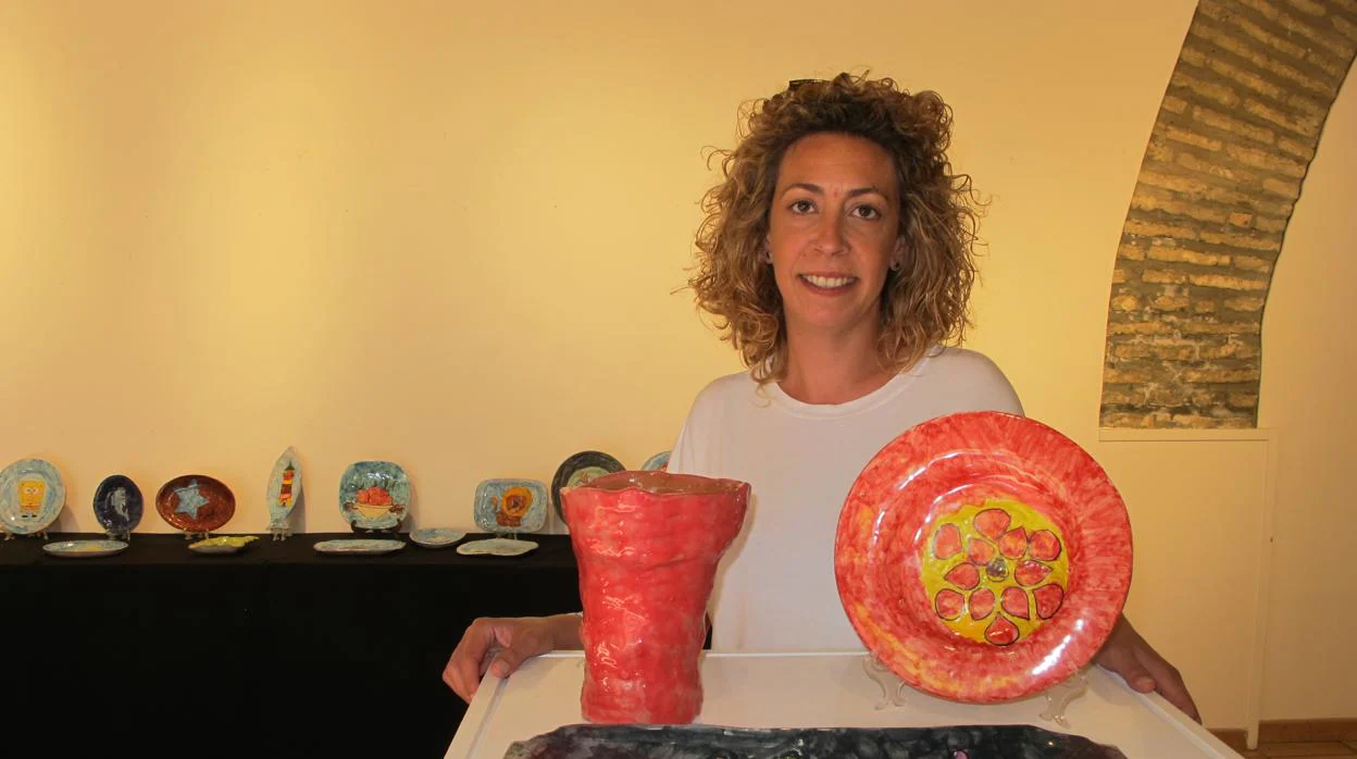 Elena Bellido junto a obras de sus alumnos del taller de cerámica expuestas en la sala de La Misericordia