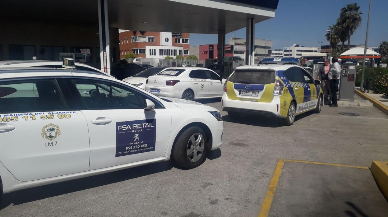 Una patrulla de la Policía Local junto a varios taxistas en la gasolinera de la rotonda del Pisa en Mairena del Aljarafe