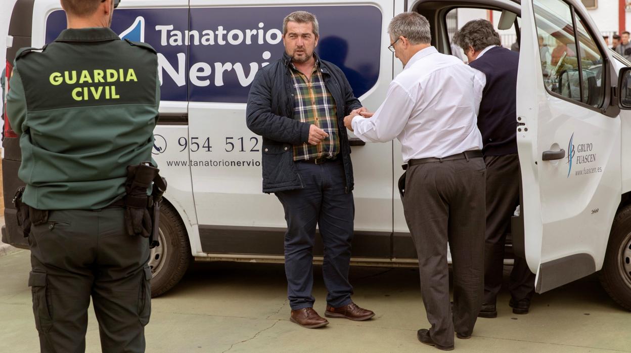 El alcalde de Aznalcóllar, Juan José Fernández conversa con un agente de la Guardia Civil y miembros de los servicios funerarios