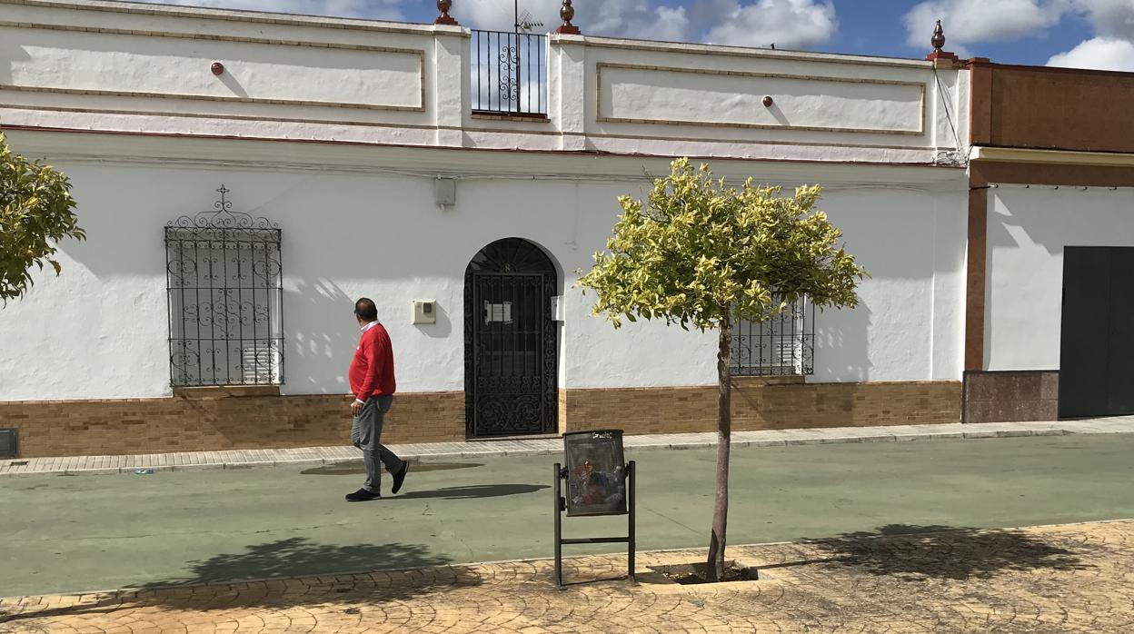 Un vecino pasea por delante de la vivienda donde fue hallada muerta Floriana, en Aznalcóllar