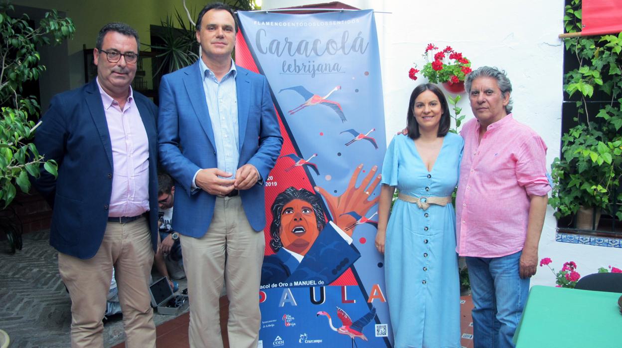 Autoridades municipales y el Caracol de Oro 2019, Manuel de Paula (a la derecha), junto al cartel de la 54 edición de la Caracolá Lebrijana