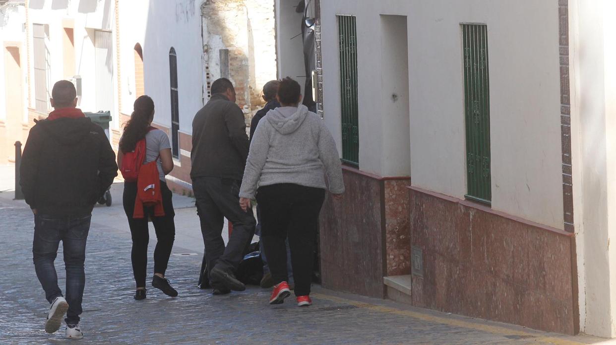 Varias personas ante la puerta de la vivienda donde se ha producido el crimen en Aznalcóllar