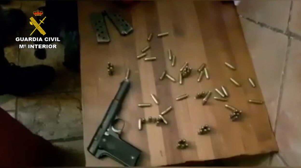 Una de las armas y la munición requisada en la casa de uno de los detenidos