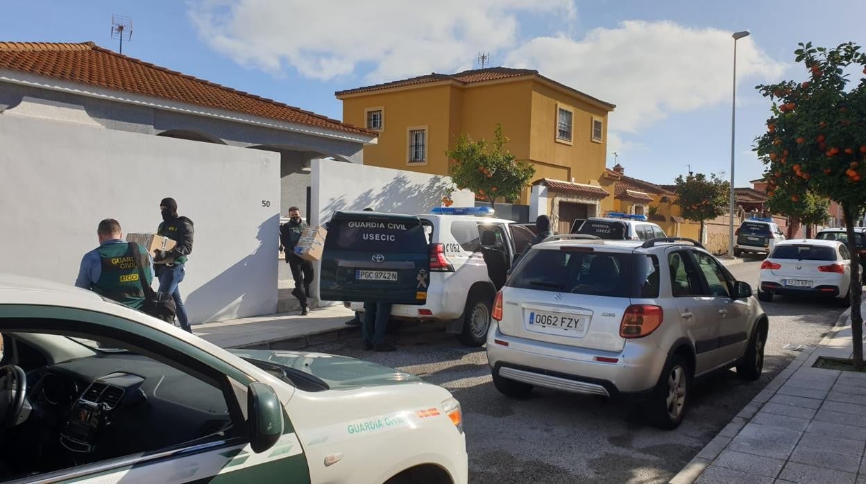 Agentes sacan documentación de la vivienda que han registrado en Arahal