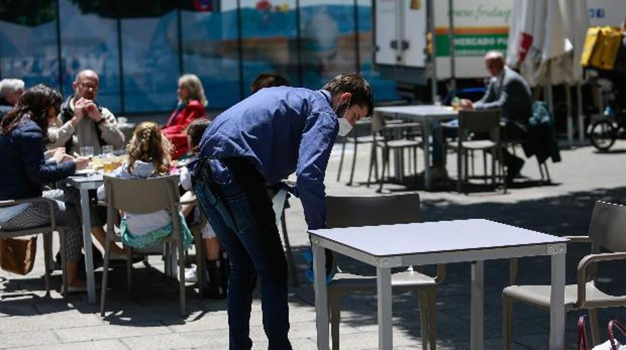 Imagen de archivo de un camarero limpiando la terraza de un bar