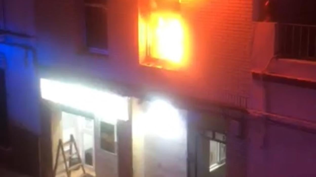 La ventana del salón donde se declaró el fuego iluminada por las intensas llamas