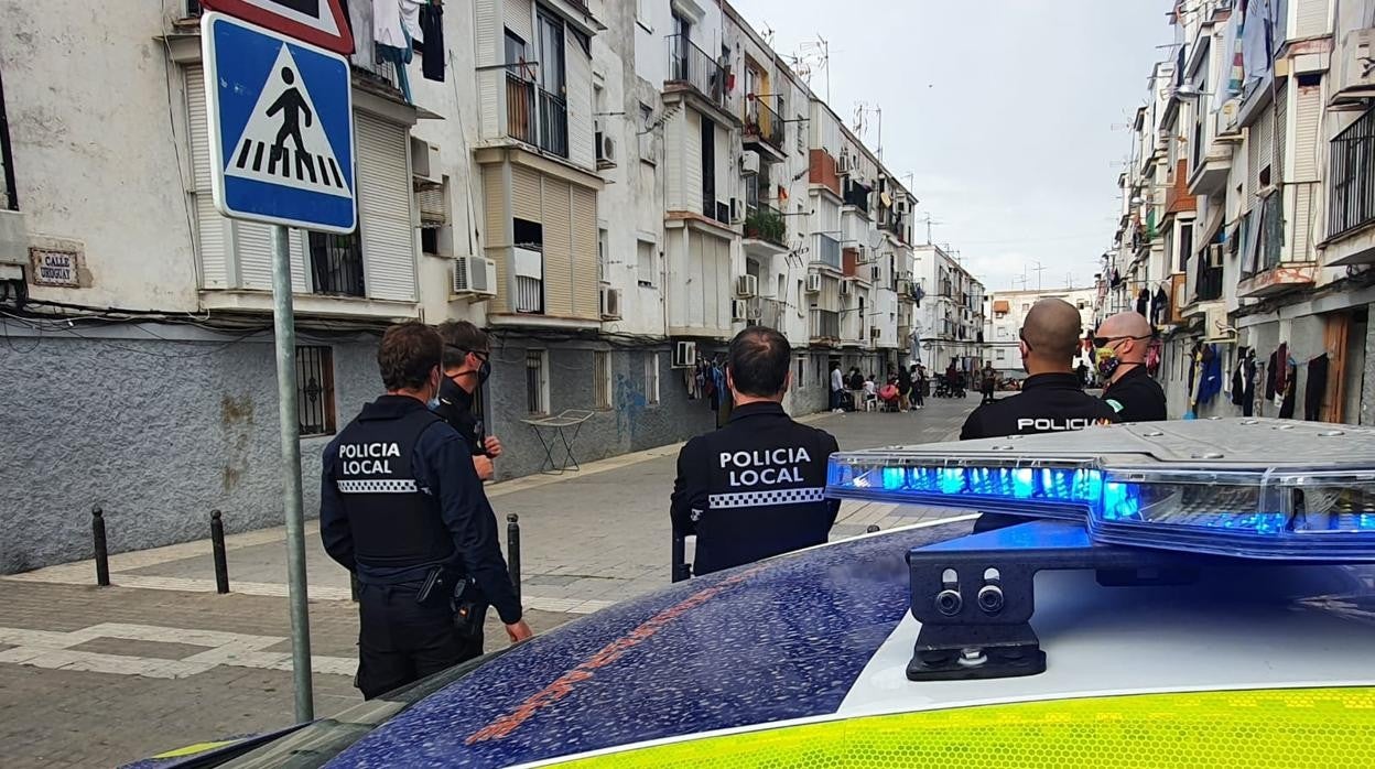 Los agentes vigilan de lejos lo que queda de la fiesta que se había organizado en la calle