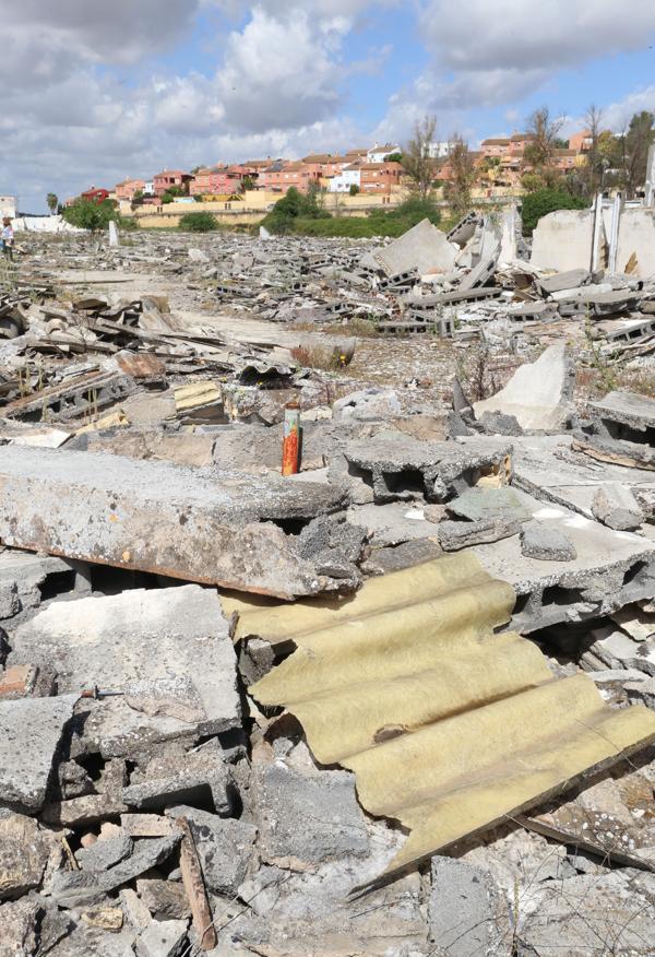 Las placas rotas de uralita están dispersas por todos lados; al fondo las casas