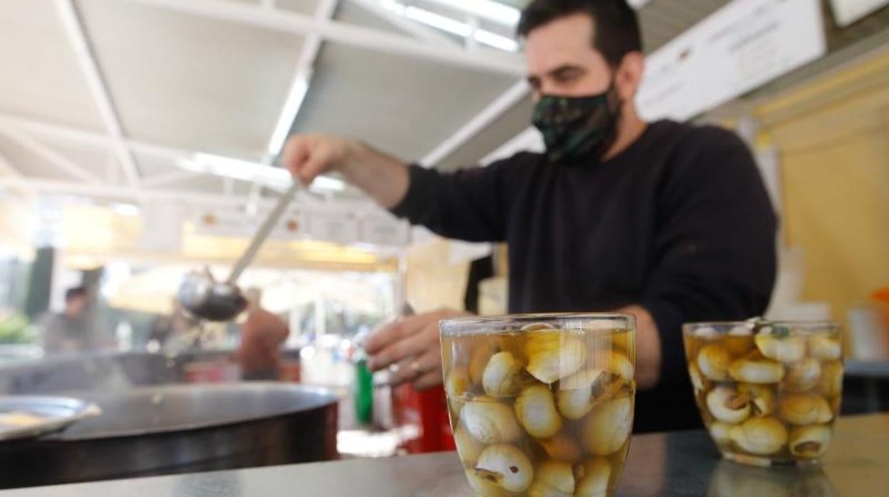 Un camarero sirve un par de vasos de carcoles