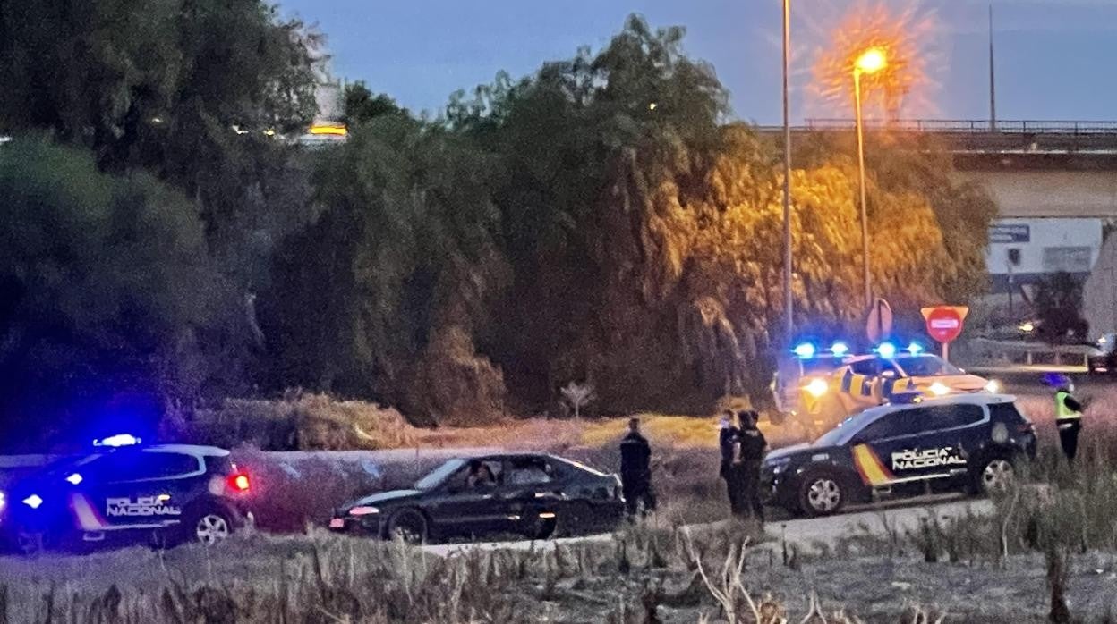 El coche de los detenidos escoltado por la Policía Nacional en un camino de servicio junto a la A-92 en Arahal
