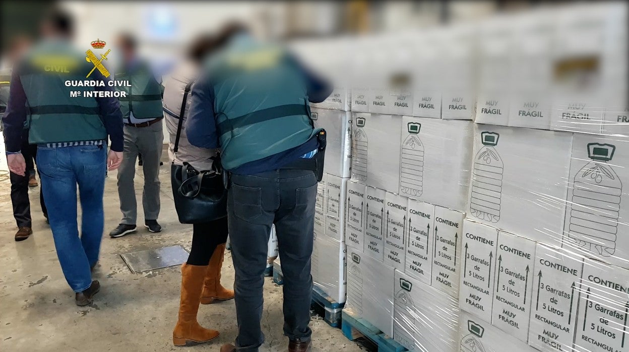 Agentes de la Guardia Civil inspeccionan las botellas de aceite virgen extra falso