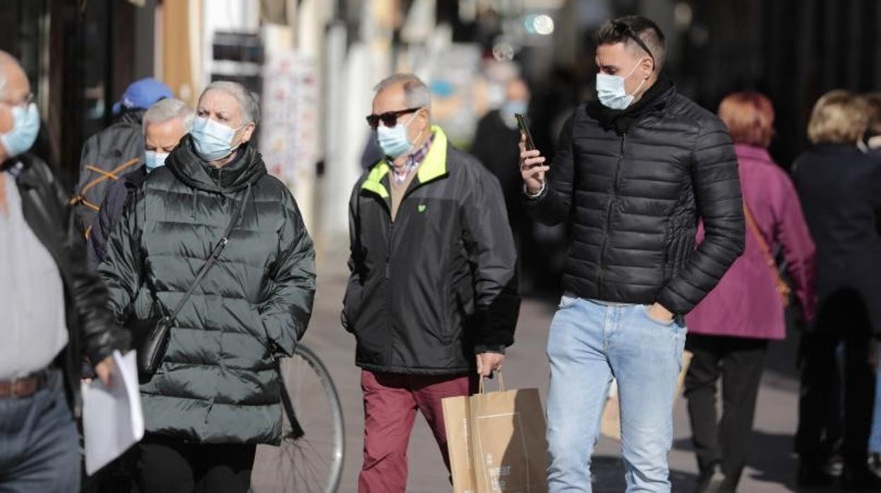 Sevillanos con mascarillas por las calles de la ciudad