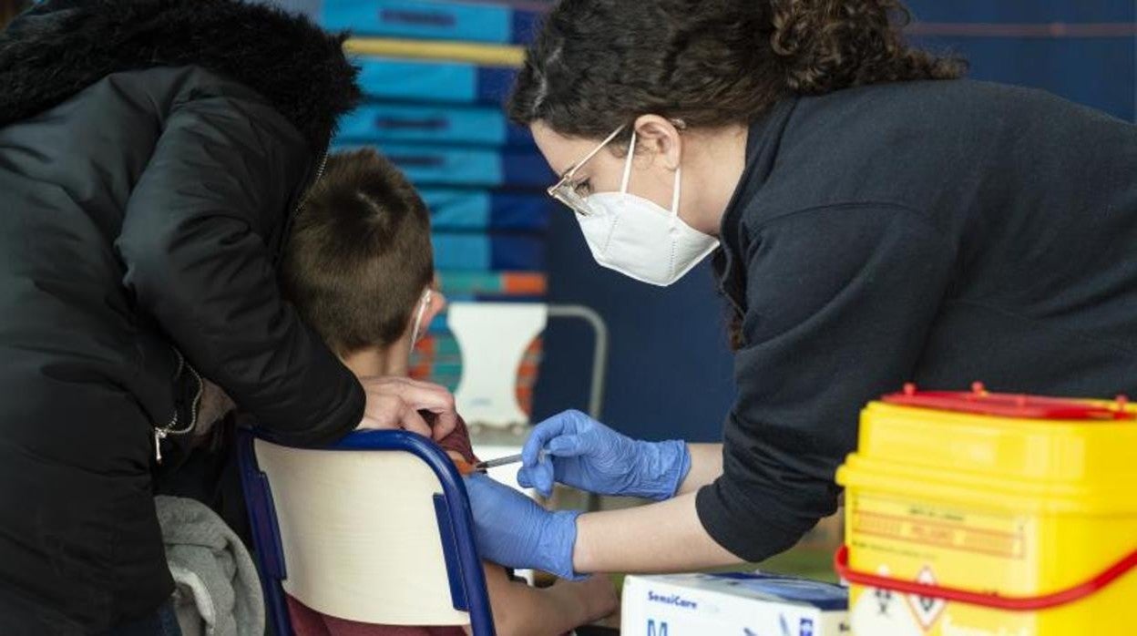 Una enfermera vacuna a un menor de edad contra el Covid