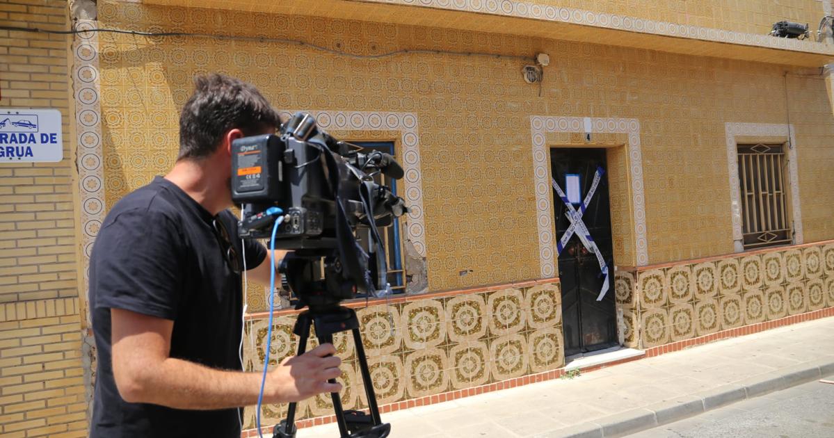 Un cámara de televisión graba la puerta de la casa de Dos Hermanas donde se han encontrado los cadáveres