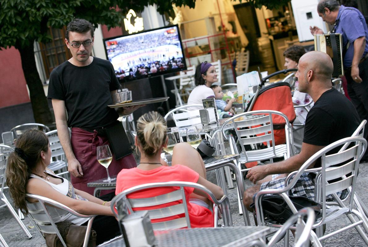 Un camarero atiende a unos clientes en el Casco Histórico