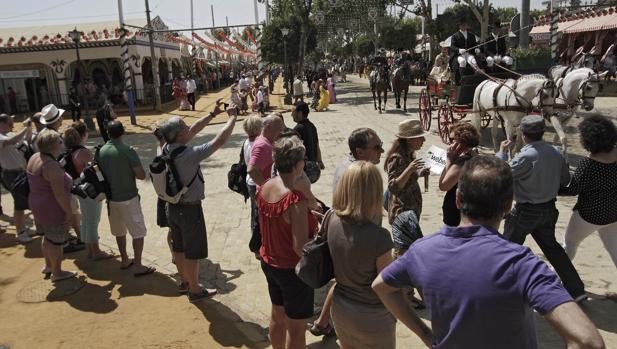 Turistas fotografían el paseo de caballos en la pasada Feria