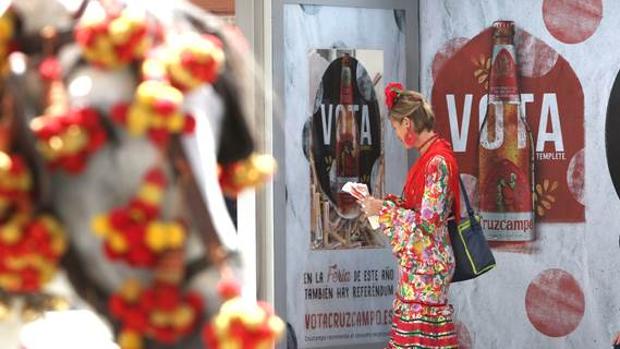 Una flamenca observa una de las marquesianas con la promoción de Cruzcampo