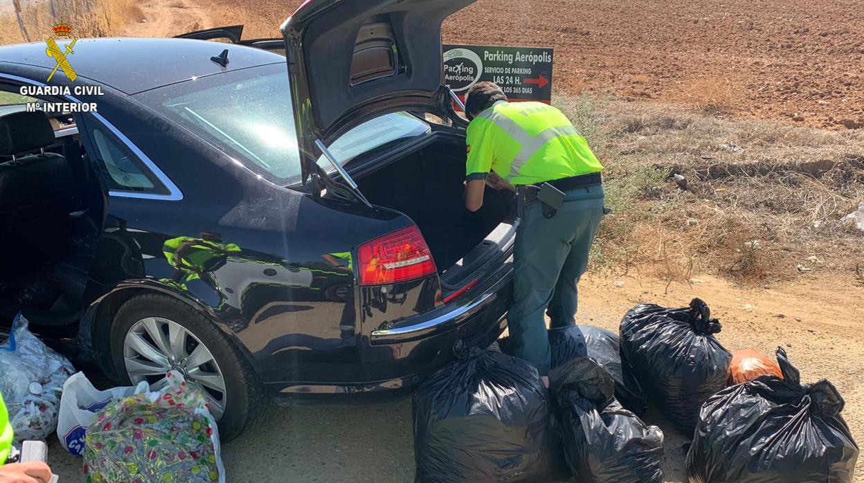 Un guardia civil saca del coche interceptado las bolsas de marihuana