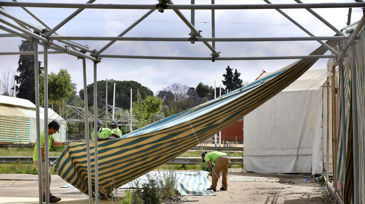 Una cuadrilla desmontando una caseta de la Feria de Sevilla este miércoles