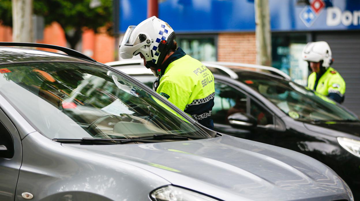 Dos agentes en un control policial a conductores en las calles de Sevilla
