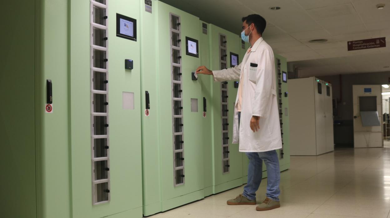 Un profesional del Virgen del Rocío junto a una máquina que facilita uniformes