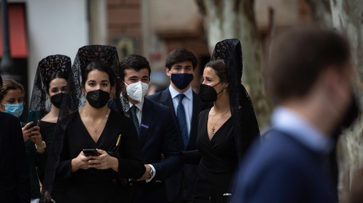 Varias jóvenes vestidas de mantilla, junto a la parroquia de la Magdalena