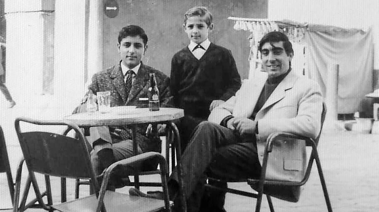 En el Arco. La imagen es de la segunda mitad del siglo pasado. Y vemos a los dos hermanos Loreto, Miguel y Felipe, en los veladores de la terraza que se ubicaban al lado del arco macareno. Felipe es el más pequeño que posa junto a un amigo de la familia