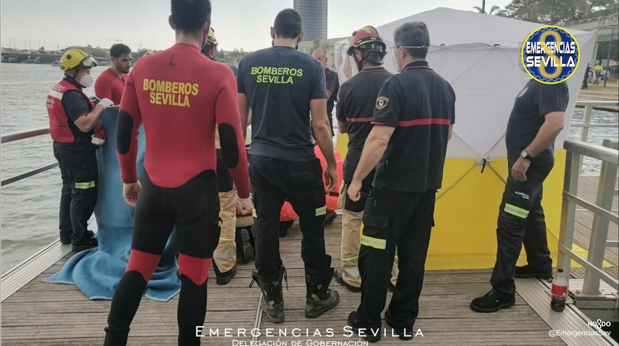 Un momento del rescate del cuerpo sin vida de un varón que se ha arrojado al río Guadalquivir