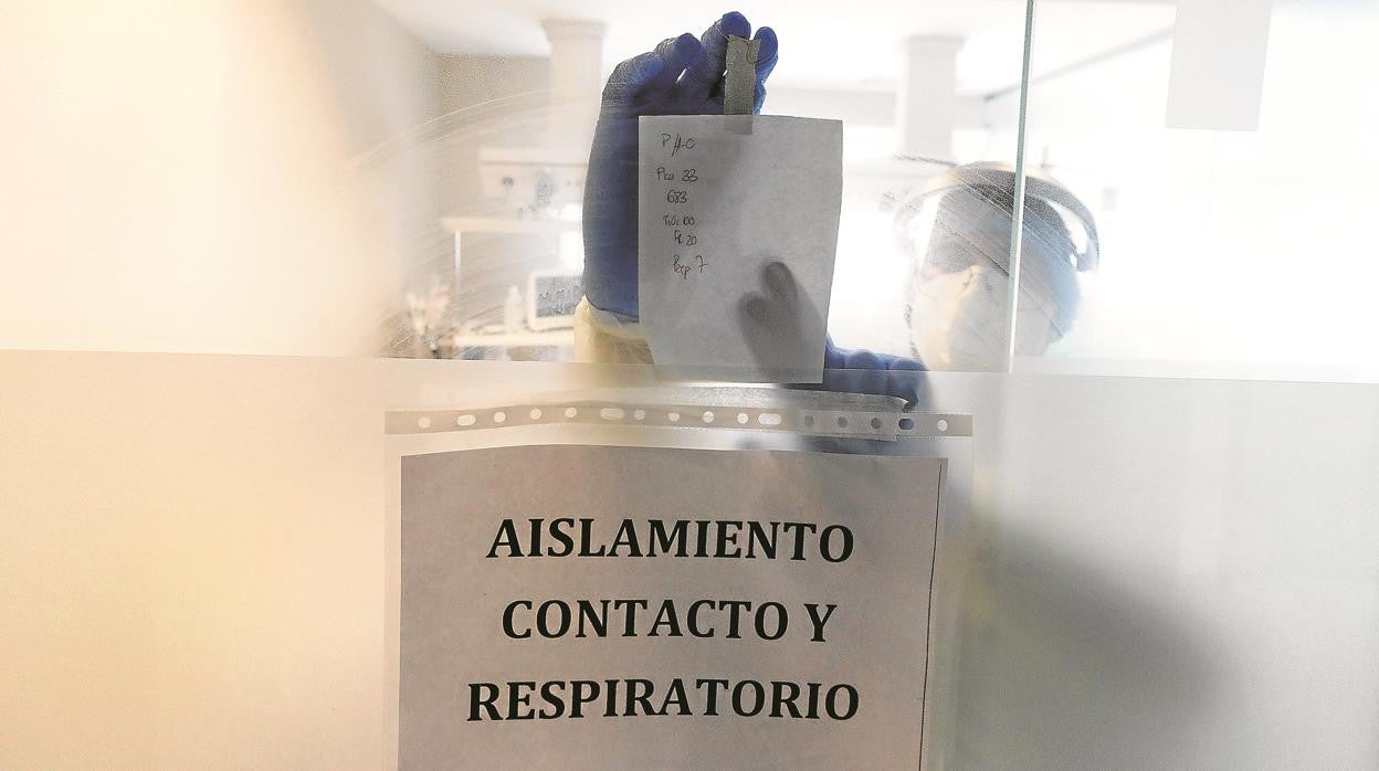 Un sanitario se comunica con el exterior desde una sala aislada por el Covid