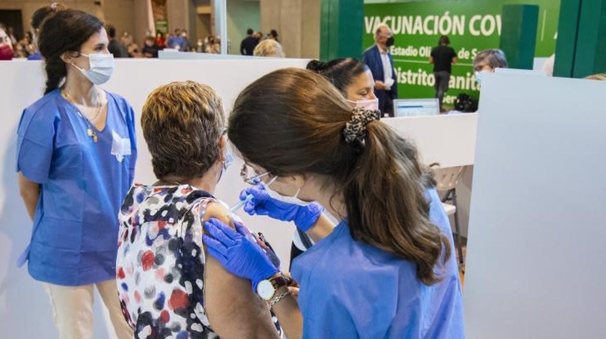 Una mujer recibe la vacuna contra el Covid en el estadio de la Cartuja