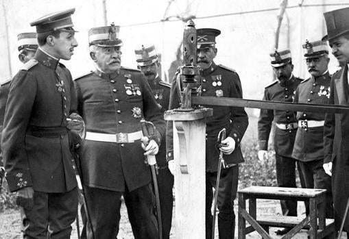 Alfonso XIII examina los efectos de un disparo hecho por un proyectil fabricado en Sevilla