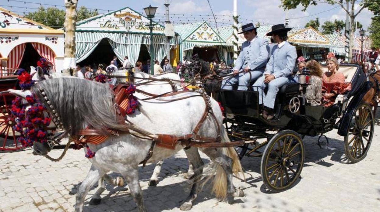 Coche de caballos recorriendo el Real de la Feria