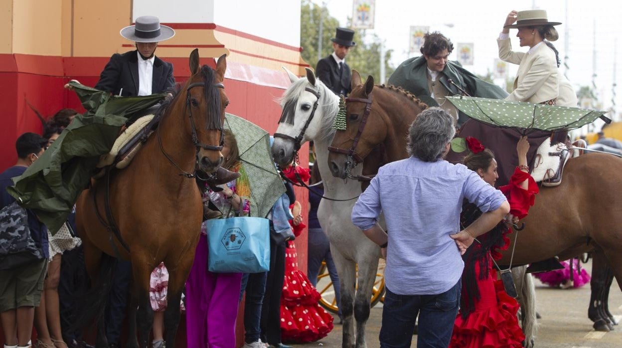 Caballistas protegiéndose de la lluvia en la zona de la portada