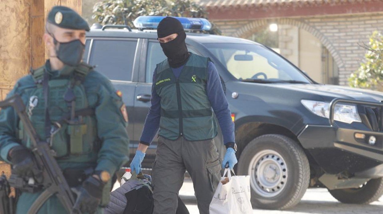 Imagen de archivo de un agente de la Guardia Civil saliendo de la casa de un traficante en la provincia de Sevilla