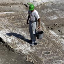 Operario trabajando sobre uno de los mosaicos hallados