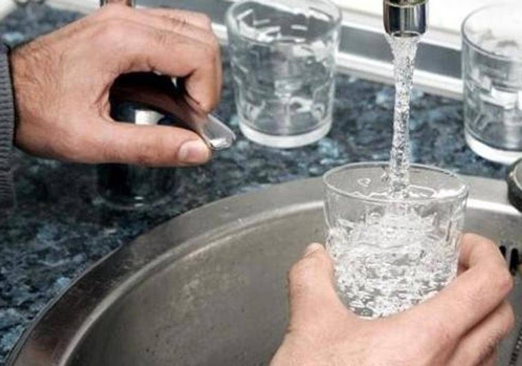 Una persona llena un vaso de agua