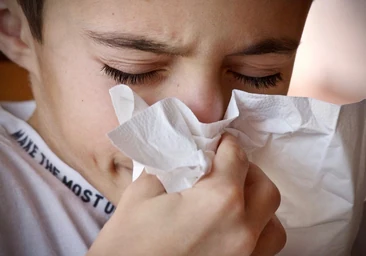 Un niño, los primeros en contagiarse del Covid-19, se suena la nariz