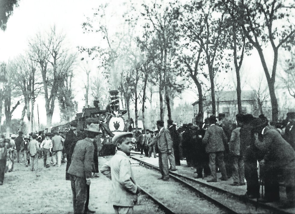El Tren Botijo, con el emblema pintado en el frontal de la locomotora, entra en una estación a principios del siglo XX