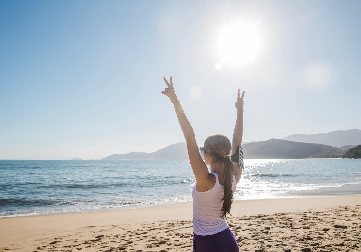 Una mujer, practicando deporte en la playa.