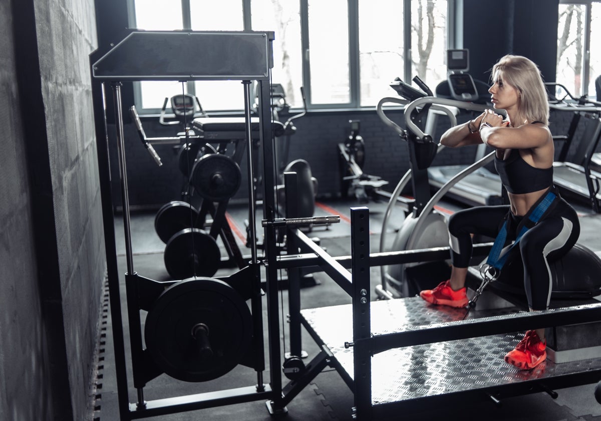 Atleta utilizando una máquina de sentadilla con cinturón