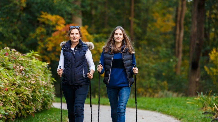 Dos mujeres, practicando marcha nórdica.