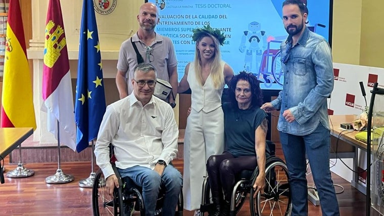 Miriam Salas posa feliz y orgullosa junto a una representación de sus atletas tras leer su tesis doctoral