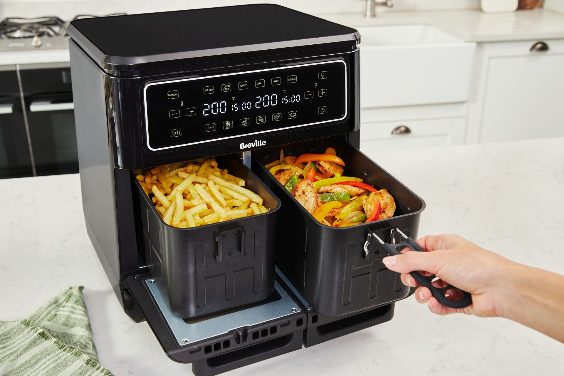 Esta Breville Halo Dual Flexi Air Fryer XL permite 12 formas de cocinar y tiene una capacidad de cocción de 11 litros. Destaca por un compartimiento de cocción extragrande dividido en dos zonas de 5,5 litros cada una, lo que permite cocinar dos recetas a la vez. Usa hasta un 99,5% menos de aceite y es un 50% más eficiente que un horno convencional. Precio: 229 euros.