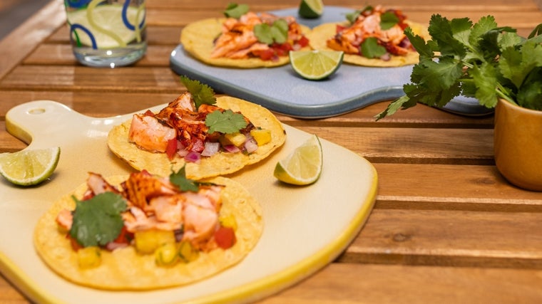 Tacos de salmón noruego con guarnición de pico de gallo de piña y cilantro.