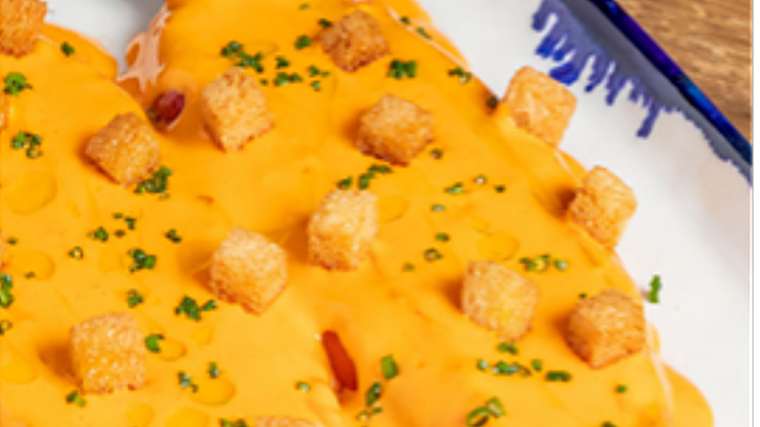 Pieles de bacalao sufladas con salsa de manitas.