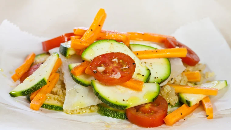 Hake in papillore with vegetables.