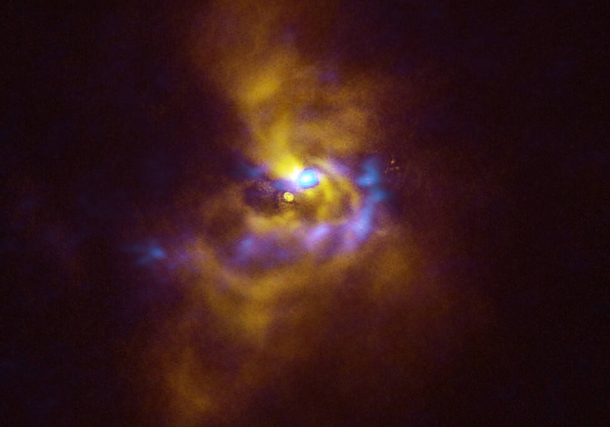 En el centro, la joven estrella V960 Mon,  a más de 5.000 años luz de distancia en la constelación de Monoceros. Está rodeada de material polvoriento con potencial para formar planetas