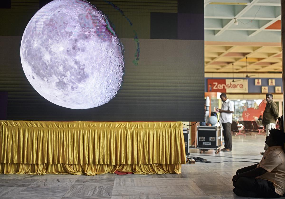 Un hombre observa la retransmisión en directo del aterrizaje en el polo sur de la Luna de la misión Chandrayaan-3