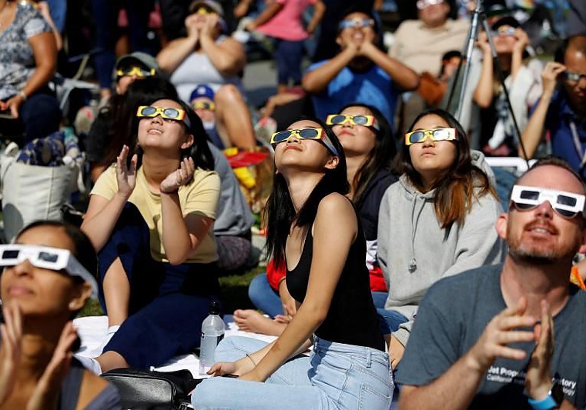 La gente observa el eclipse solar en el césped del Observatorio Griffith en Los Ángeles